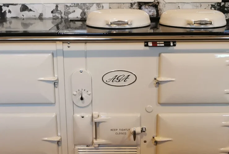 Cream 4-oven aga cooker integrated into a modern kitchen setup with light grey cabinetry and wooden countertop, demonstrating the refined craftsmanship of John Wray Range Cookers.