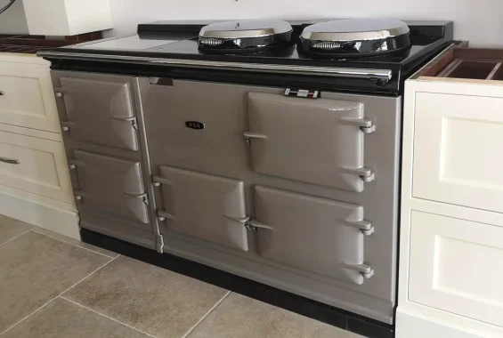 Modern grey aga cooker installed in a bright, light-toned kitchen with cream cabinetry and tiled flooring by John Wray Range Cookers.